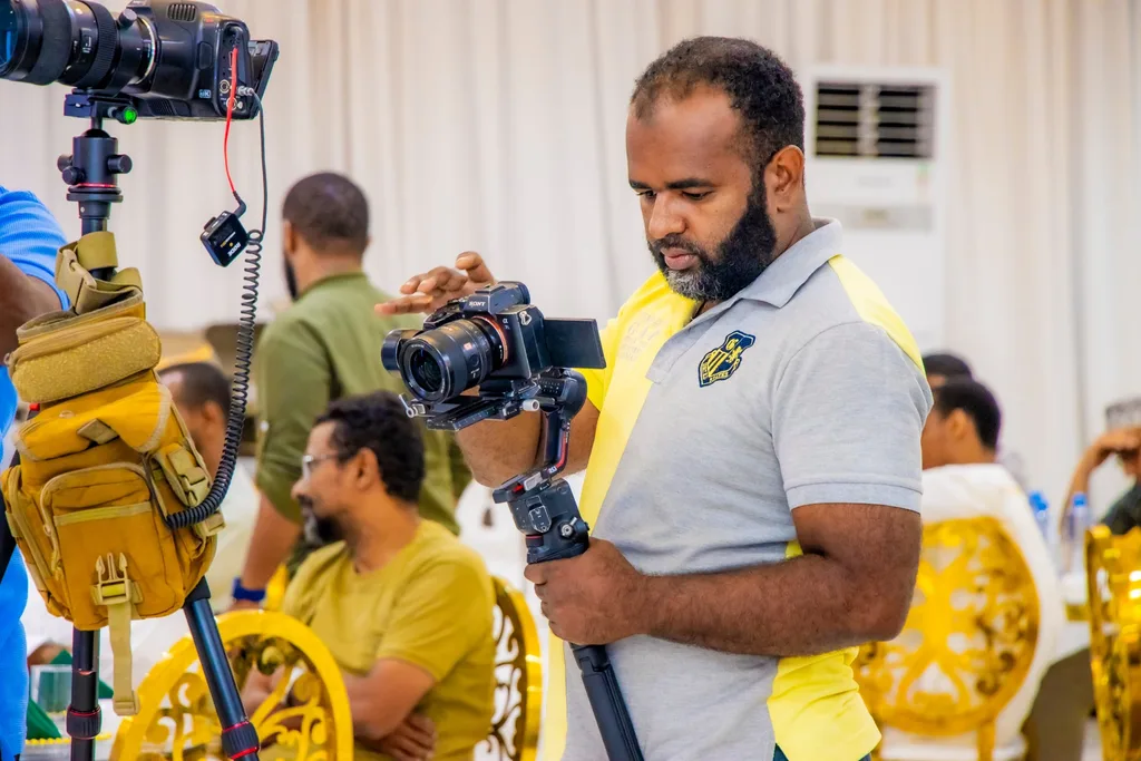 A KAMMP media volunteer films the Iftar CME with a camera rig, 2025
