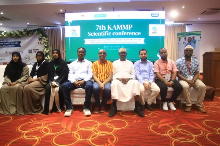 A panel of ten seated on the stage under the 7th KAMMP Scientific Conference banner, 2025