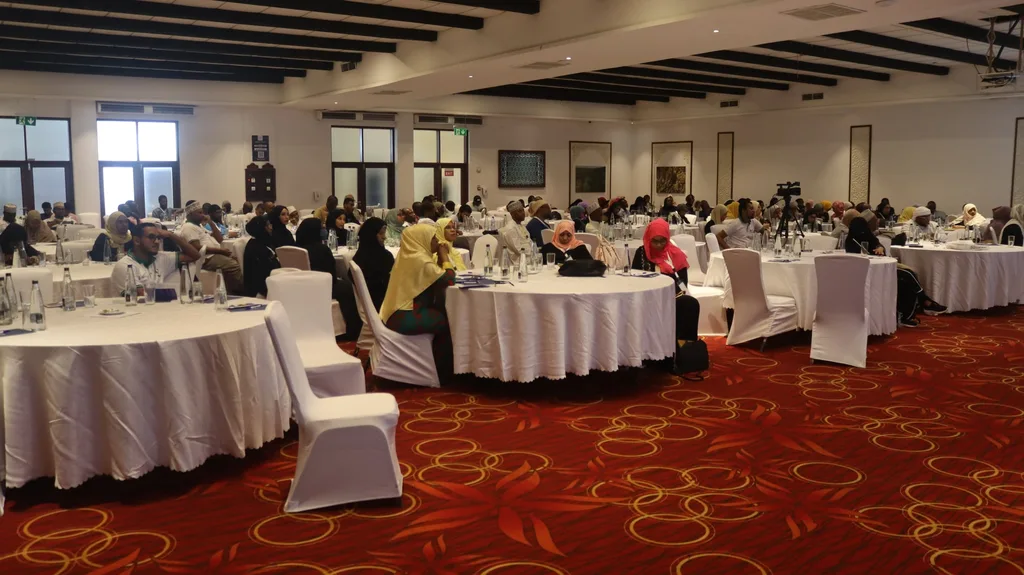 The conference hall of the 5th KAMMP Scientific Conference from the back, round tables and a red patterned carpet, 2023