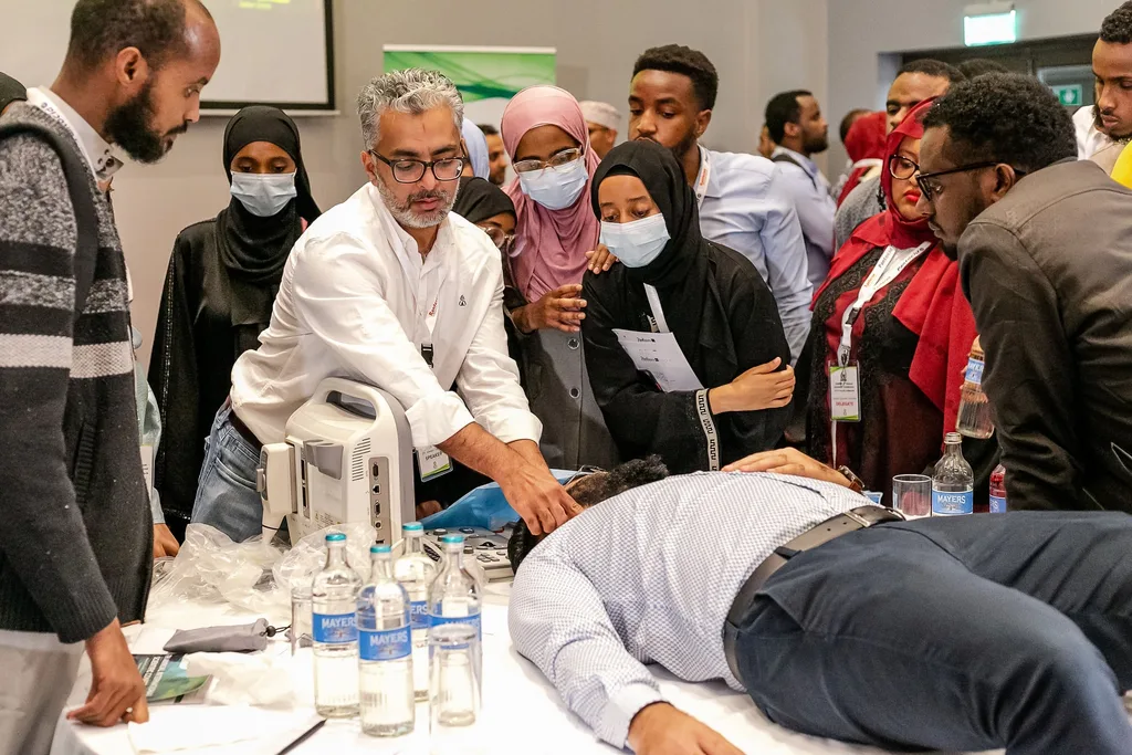 Basic life support practice at the 4th KAMMP conference: delegates take turns on a volunteer under a facilitator's eye, Nairobi 2022