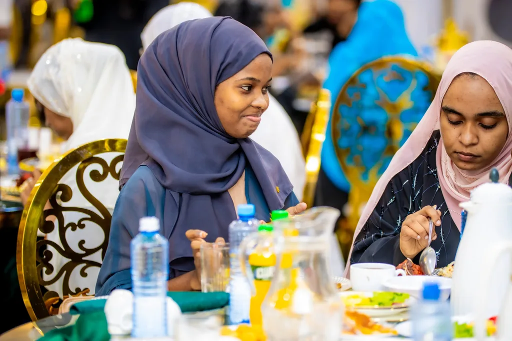 Two members at a dinner table during a KAMMP Iftar, 2025