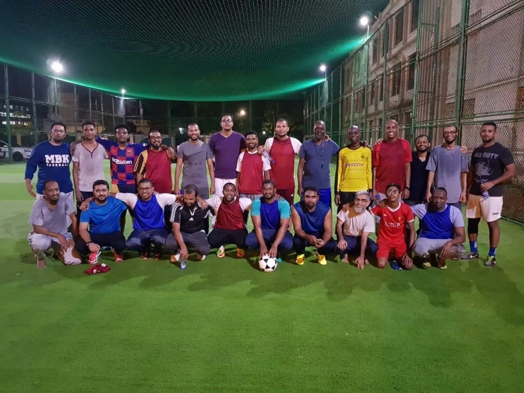 The KAMMP football team photographed together on the pitch at night