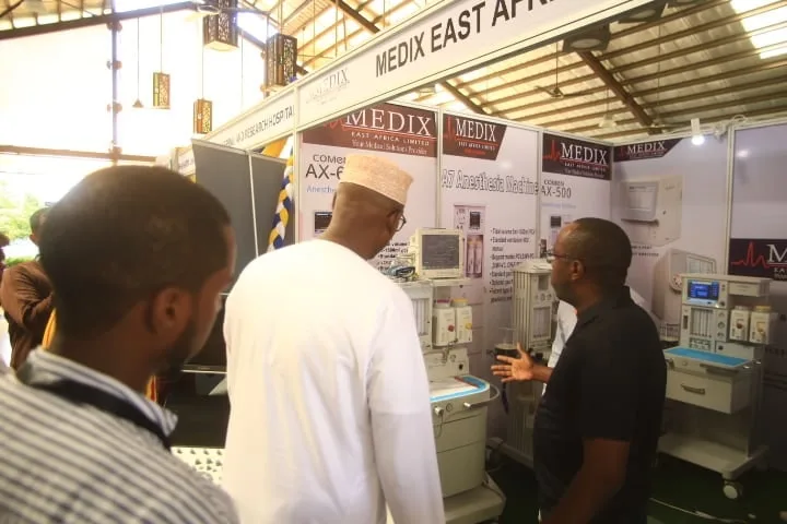 Delegates look over medical equipment at an exhibitor's stand, 7th KAMMP Scientific Conference, 2025