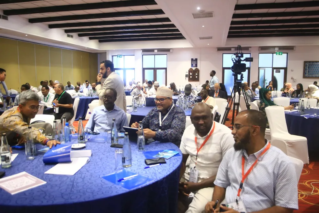 The conference hall of PrideInn Paradise, Mombasa, full of delegates at blue round tables for the 7th KAMMP Scientific Conference, 2025