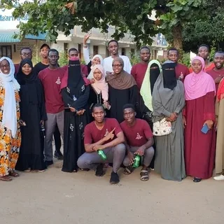 Young members and students in KAMMP shirts gathered outdoors for a group photograph, 2023