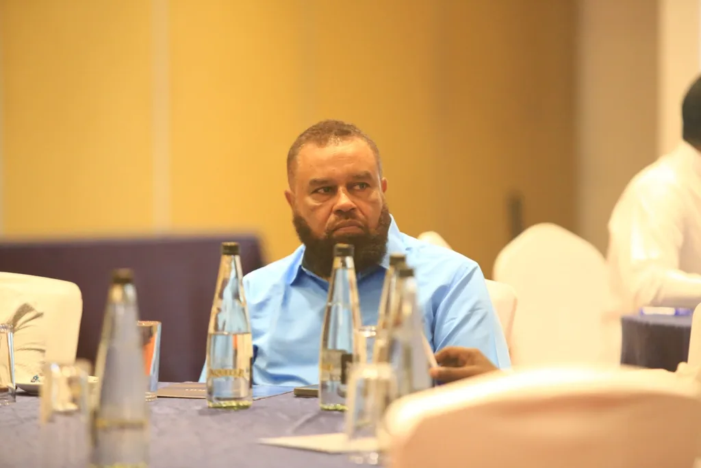 A delegate at a conference table during a session of the 7th KAMMP Scientific Conference, 2025