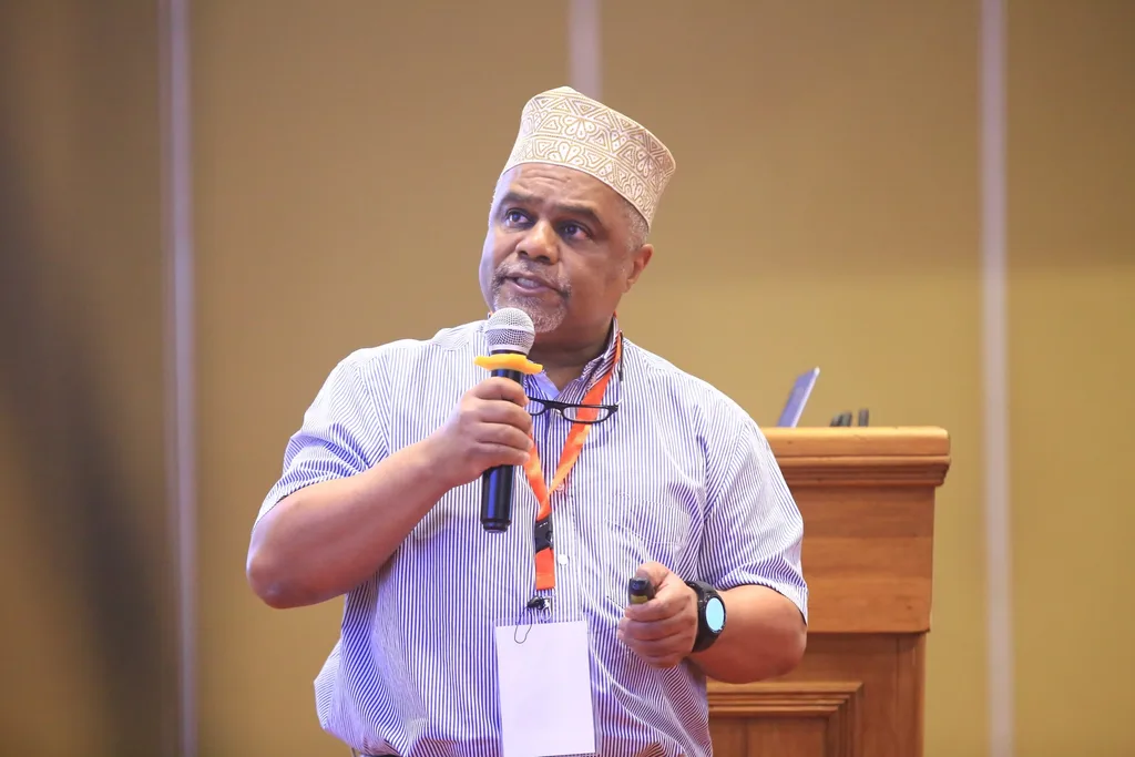 A delegate asks a question from the floor with a microphone at the 7th KAMMP Scientific Conference, 2025