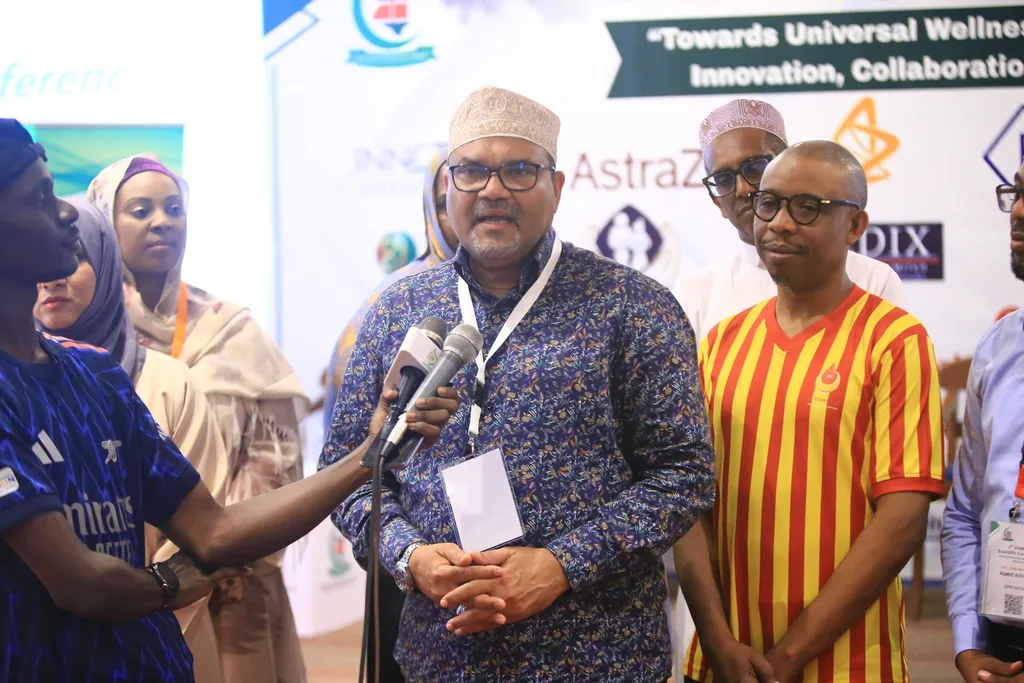 A media interview in front of the sponsor wall at the 7th KAMMP Scientific Conference, 2025