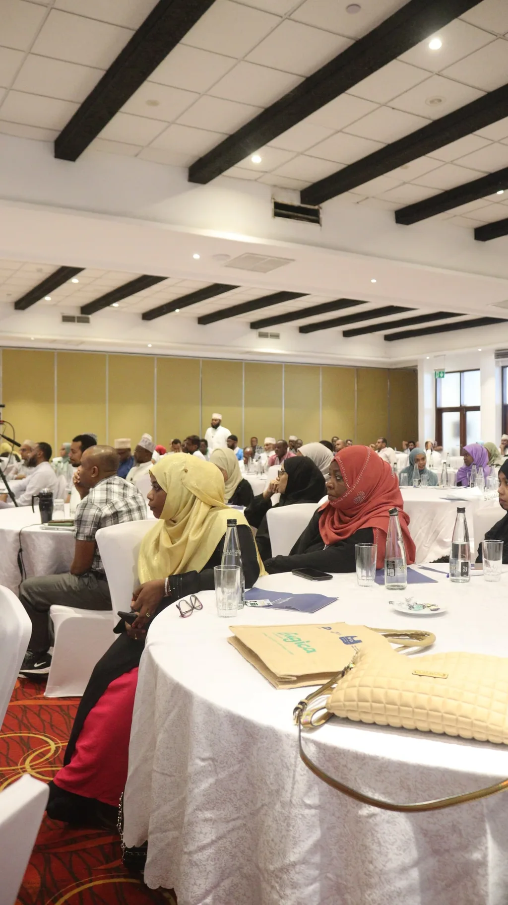 A packed plenary hall at the 5th KAMMP Scientific Conference, delegates at round tables as far as the stage, Mombasa 2023