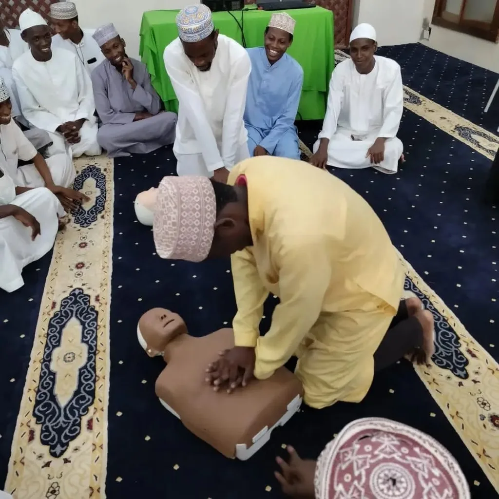 A participant practises chest compressions on a manikin during a Lifesavers workshop in a mosque